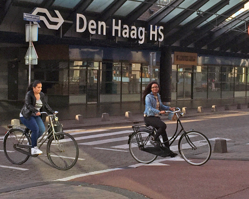 girls riding bikes near train station in The Hague Netherlands